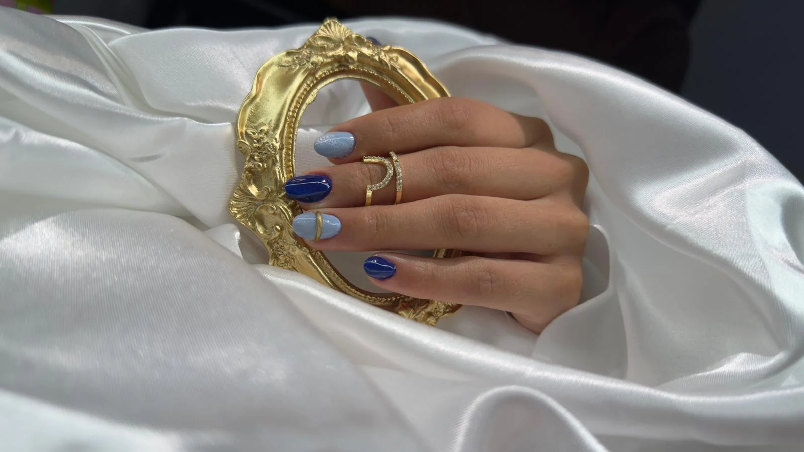 Trabajo de uñas azul intenso con detalle dorado